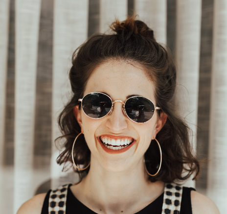 Smiling woman wearing sunglasses and hoop earrings