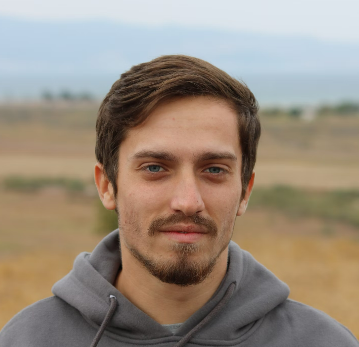 Bearded man standing outdoors in casual hoodie